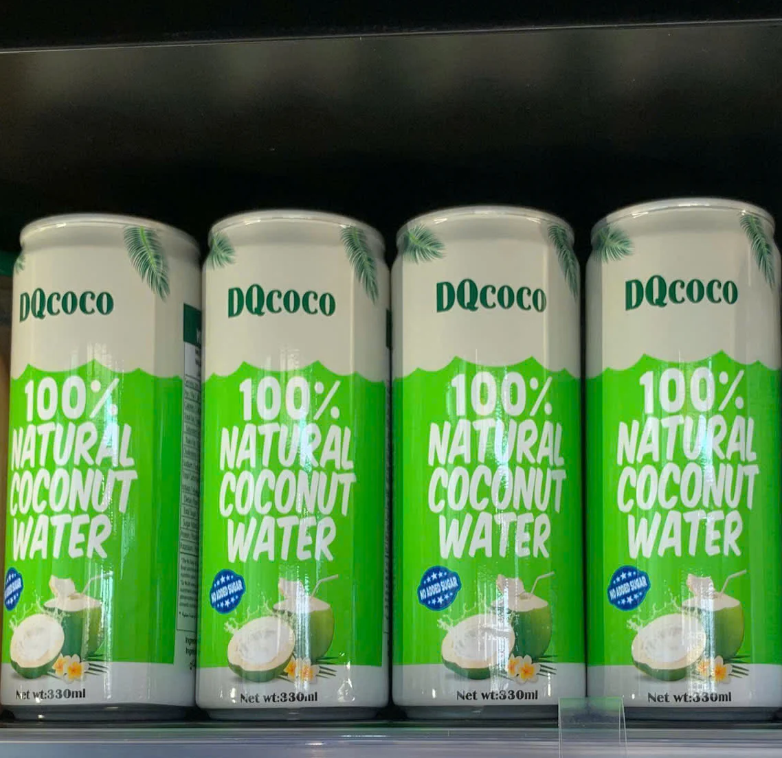 DQcoco 100% natural coconut water cans on a chilled retail shelf in Dubai, UAE